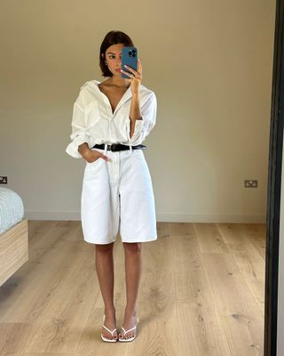@smythsisters wearing long white shorts, button down shirt and heeled thong sandals