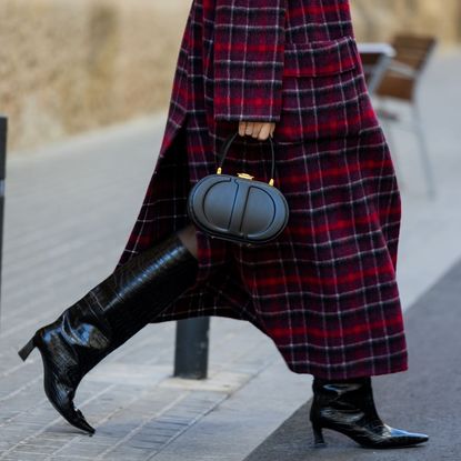 Miss Dior Perfume Cyber Monday: A woman wearing a checkered coat, black leather boots and a black Dior handbag