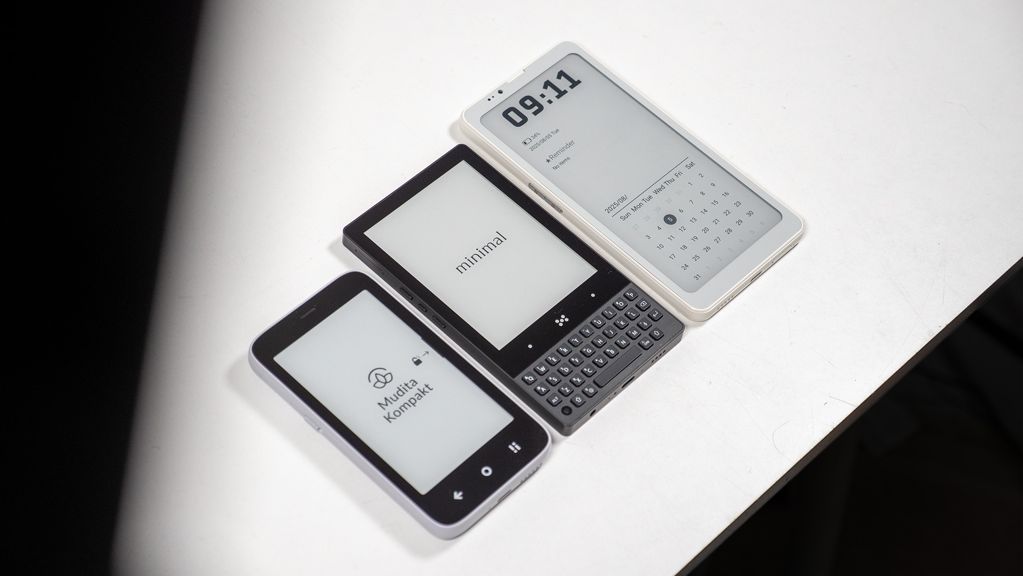 A Mudita Kompakt, Minimal Phone, and Bigme HiBreak Pro next to each other on a white table