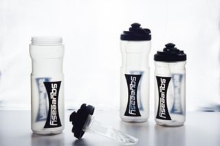 Three Squeeasy waterbottles on a white background, on far left is open with the lid off displaying the gel insert pouch