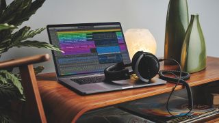 A MacBook Pro on a table with a pair of studio headphones