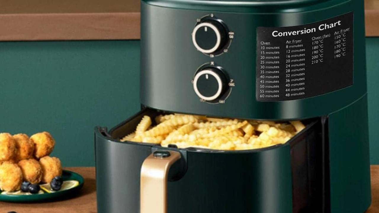 An air fryer filled with chips with an air fryer conversion chart sticker stuck to the side