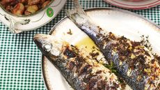 The ultimate summer food: Sardines on a dish on a green gingham tablecloth