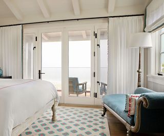 bedroom with paneled walls sea view and blue chaise longue