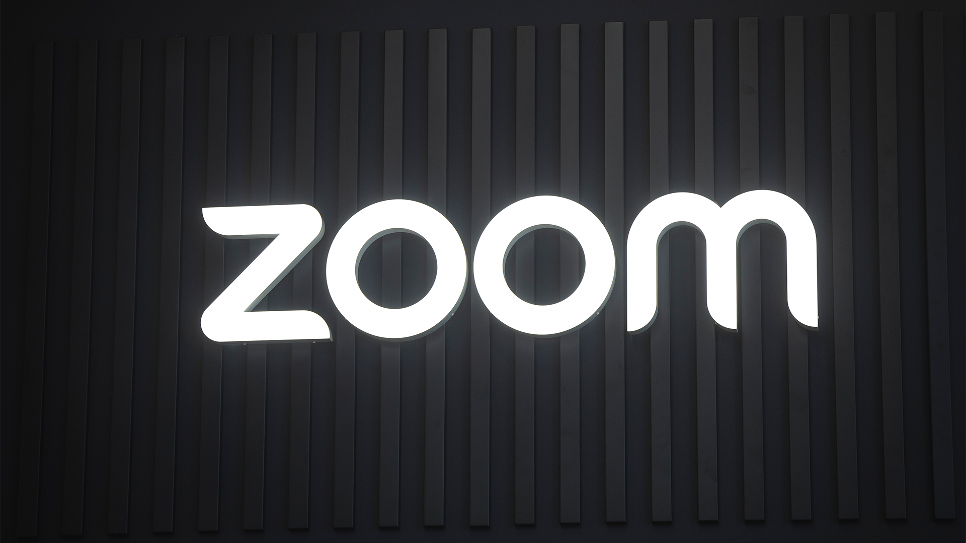 Zoom logo illuminated in white against a black background at the company's exhibitor stall at ISE 2025 in Barcelona, Spain.