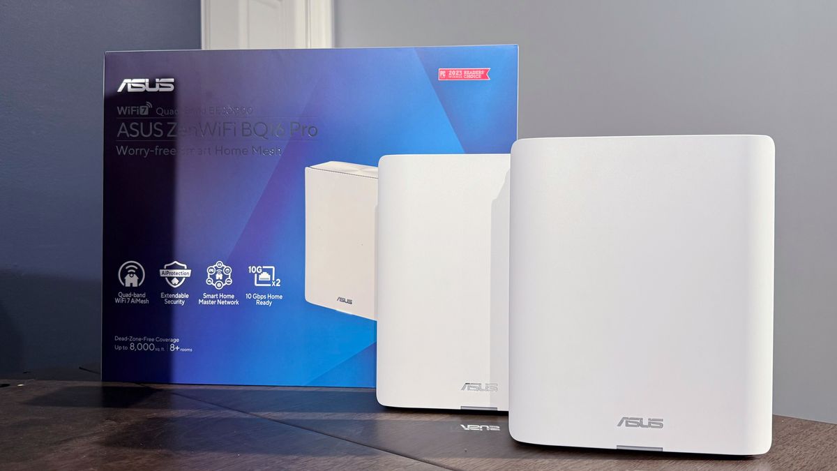 The white Asus ZenWifi BQ16 Pro next to its box on a table.