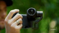 RocXZoom camera being held in the hand on a green background 