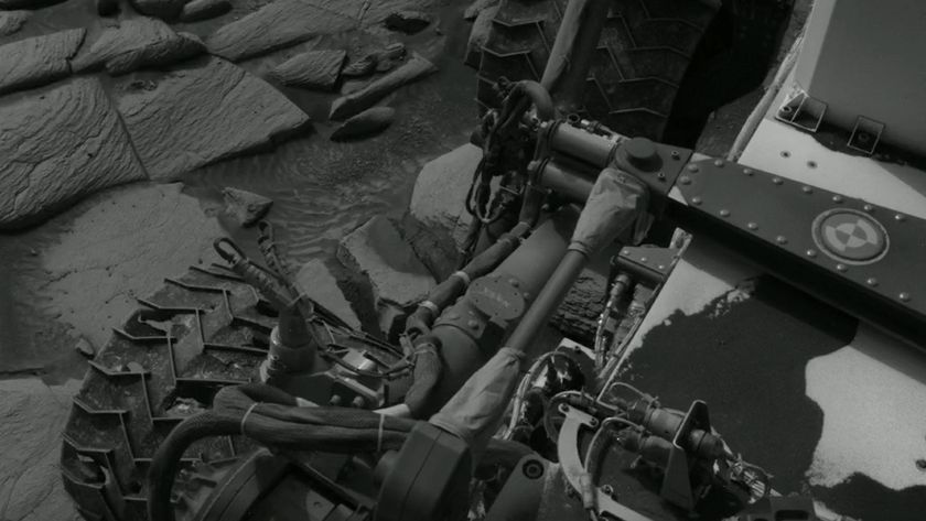 a black-and-white image of a wheeled robot, with deep gouges and cracks in its metal wheels