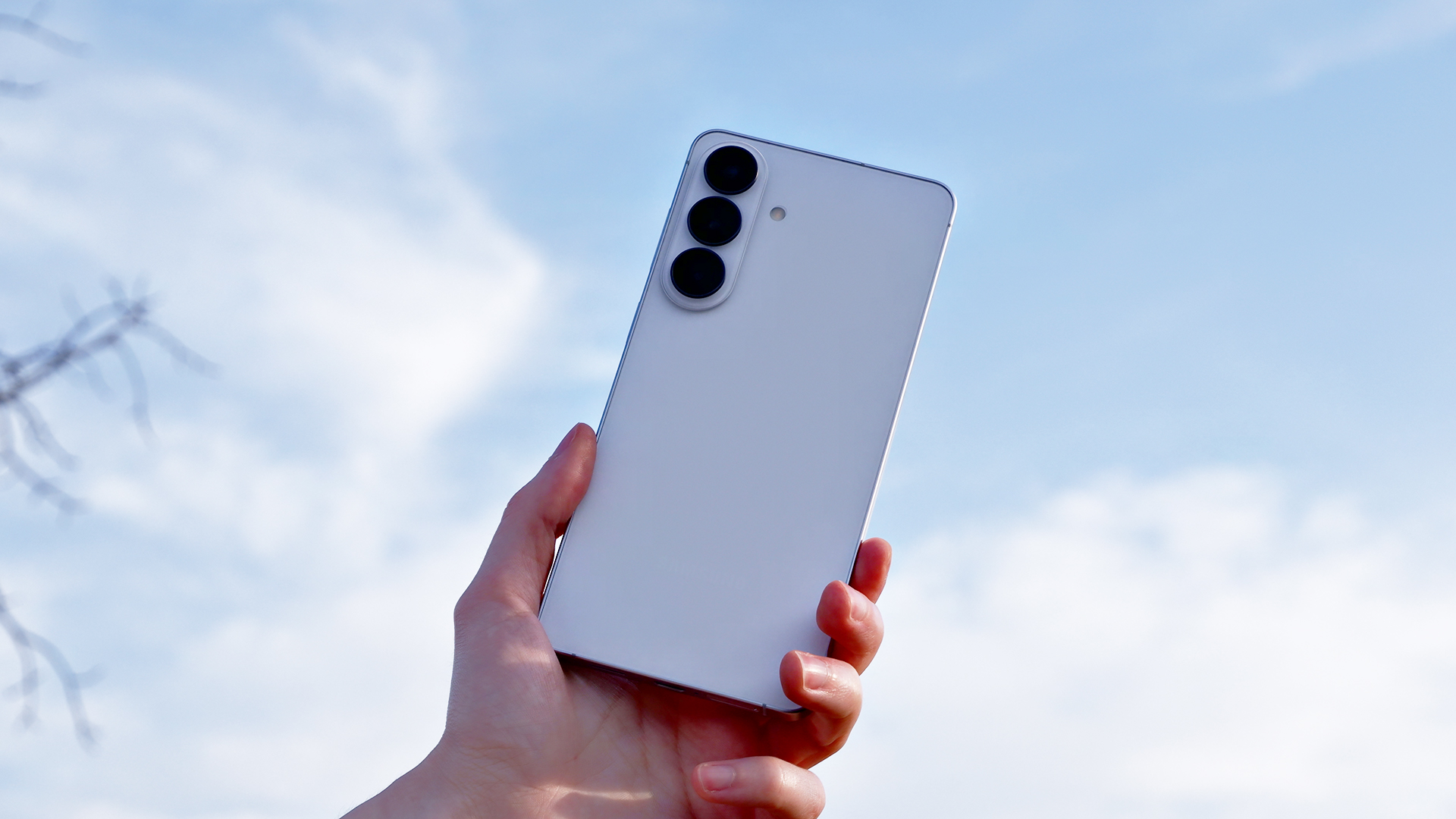 The back of the Samsung Galaxy S26 Plus against a cloudy sky.