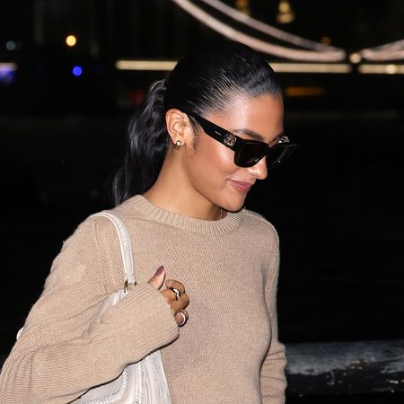 Oliva Dean wearing a tan sweater, beige asymmetrical skirt, and pointed toe heels