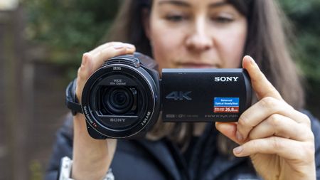 A female photographer holding the Sony AX43 camcorder