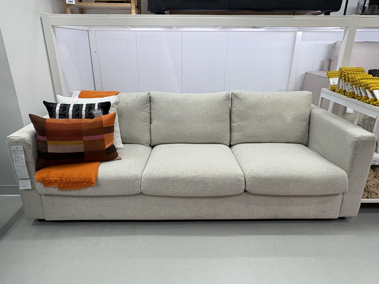 an offwhite sofa sits in an IKEA showroom.