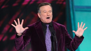 Robin Williams making a joke on a stage.