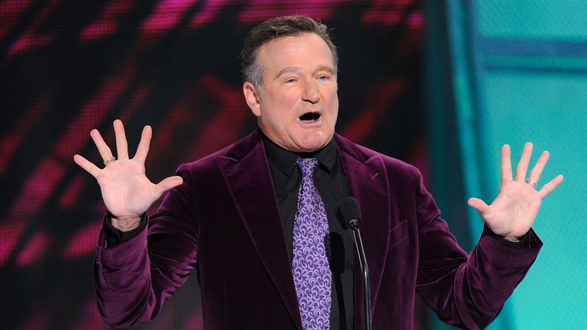 Robin Williams making a joke on a stage.