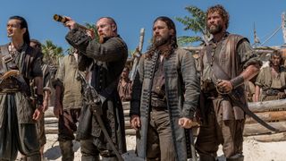 Winston Chong, Toby Stephens, Luke Arnold and Laudio Liebenberg in costume as pirates on a beach in "Black Sails"