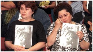 Estella Leak (R) wipes away tears during a memorial tribute for the slain Grammy-winning pop star Selena 02 April at the Los Angeles Sports Arena. Tejano music queen Selena was shot to death 31 March in Corpus Christi, Texas. On the left is Estella Leak's sister, Olivia.