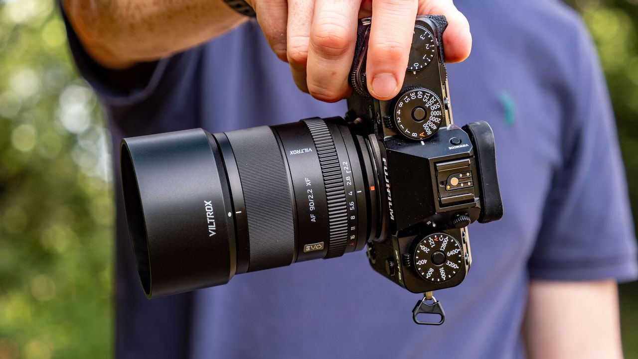 Viltrox AF 90mm f/2.2 EVO lens attached to a Fujifilm X-T5 camera, held by tech journalist and pro photographer Tim Coleman