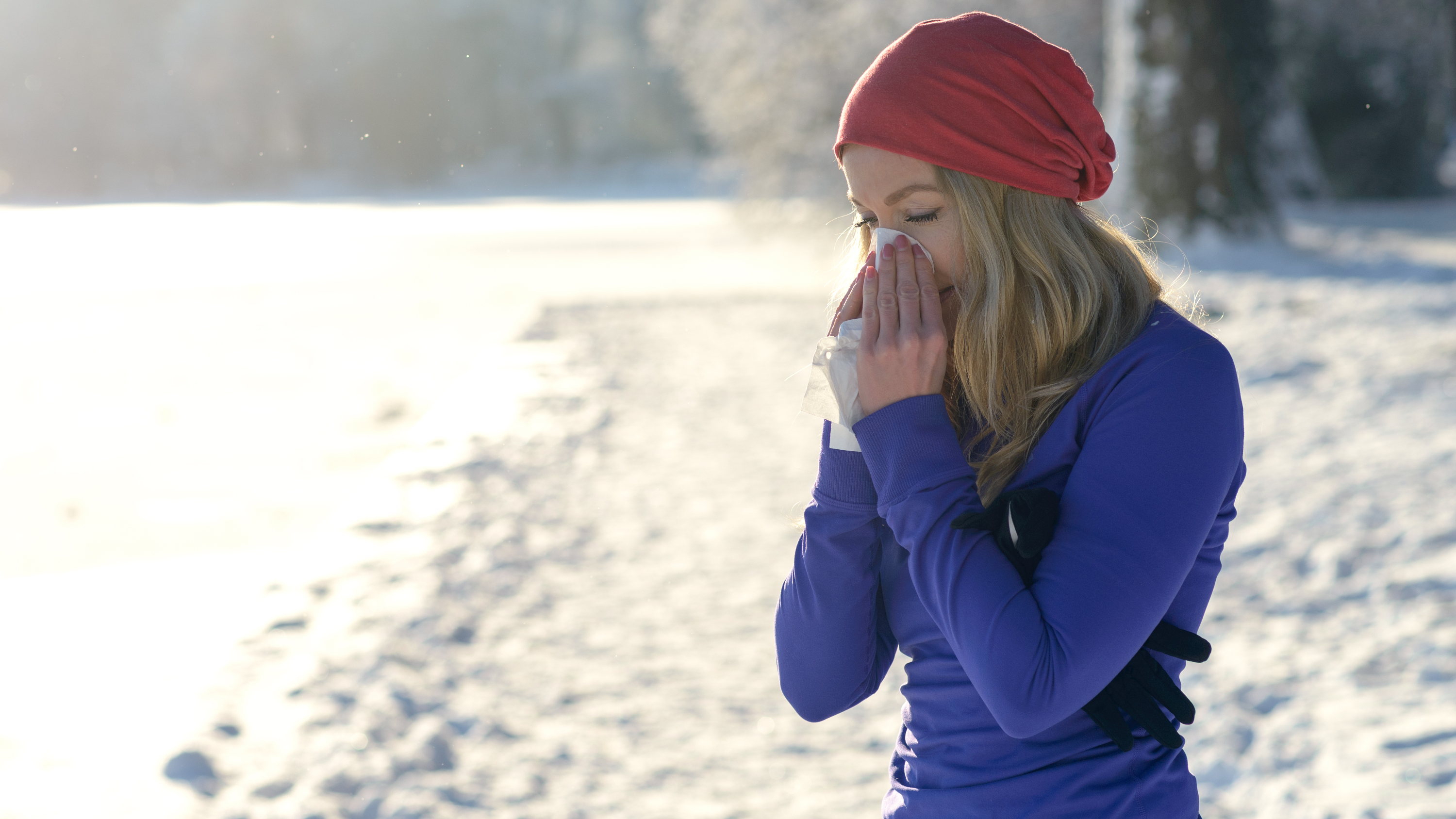 a woman on a run blowing her nose