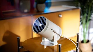 De bedste bærbare projektorer: Samsung The Freestyle står og lyser på et lille bord i en stue