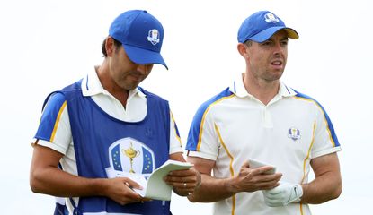 Rory McIlroy talks to his caddie during the 2020 Ryder Cup