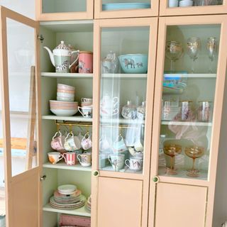 IKEA Billy bookcase after DIY transformation with various mugs and dinnerware displayed inside