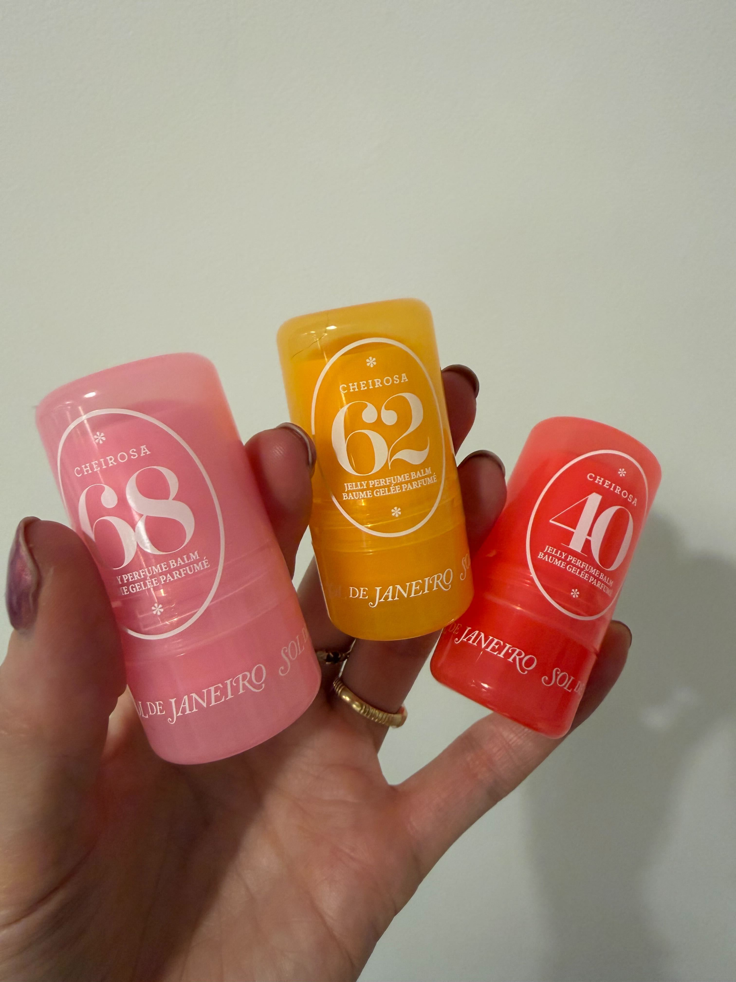 Hannah Baxter holding three sol de janeiro perfume jelly balms in her hand close up