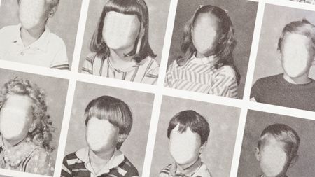A line of black and white school photos with the faces blank
