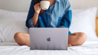 Apple laptop on a bed