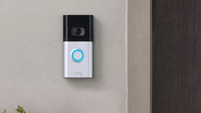 Ring Video Doorbell 4 mounted to concrete wall beside dark brown front door