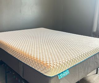 The Simba Hybrid Pro Mattress against a dark green wall.