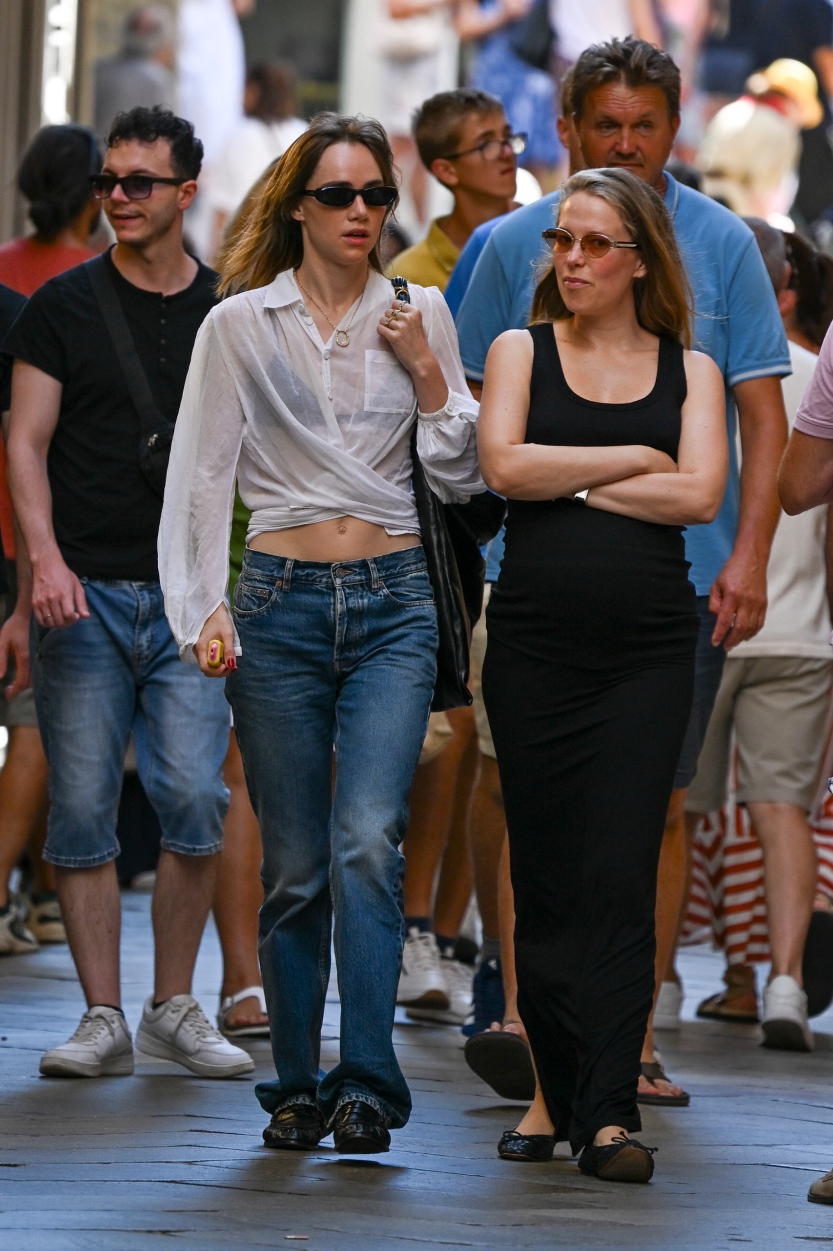 Suki Waterhouse walks down the street in Venice wearing low-rise bootcut jeans.