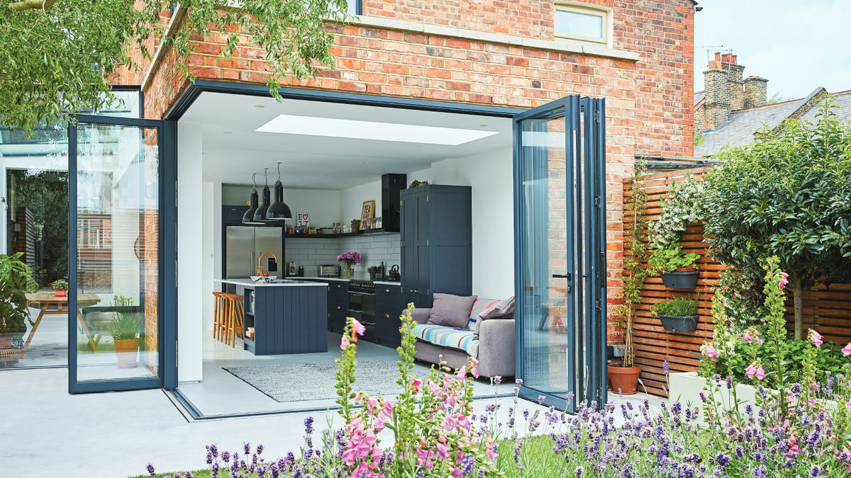 kitchen extension with brick exterior walls and corner section of bifold doors shown open