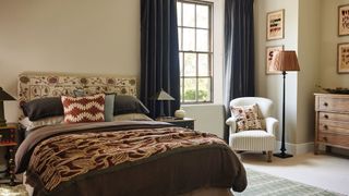 classic master bedroom with layers of soft furnishings and full length blue curtains