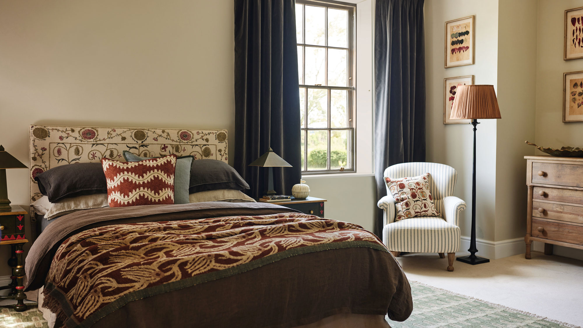 classic master bedroom with layers of soft furnishings and full length blue curtains