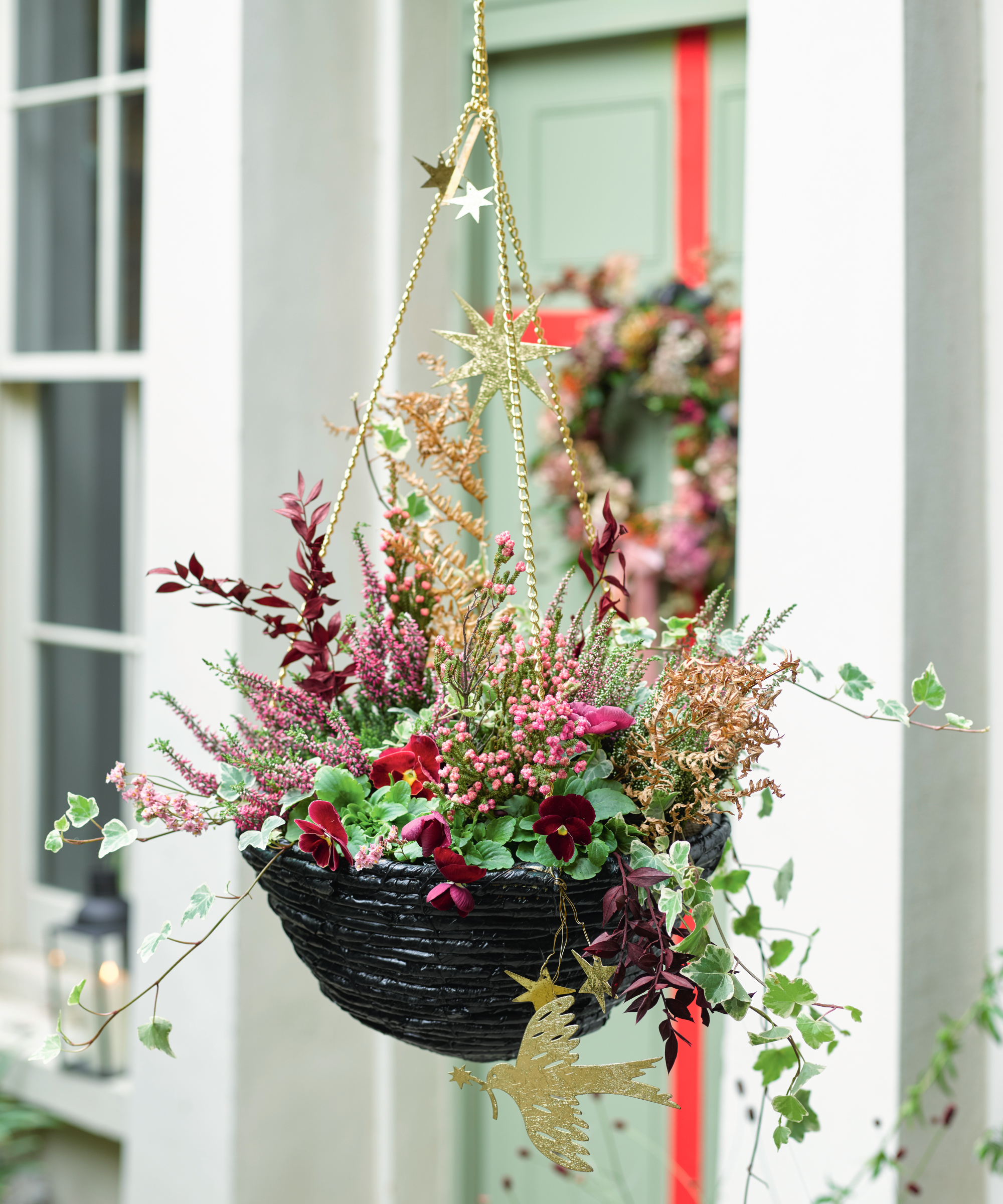 Decorating ideas. hanging basket with flower arrangement next to front door.