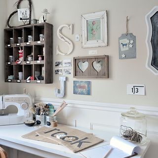 craft room with wooden shelf and sewing machine on white table and Hang framed artwork on white and cream wall