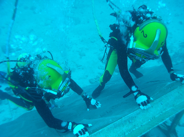 During a training session for the NEEMO 15 mission, planetary scientist Steve Squyres (left) and Japanese astronaut Takuya Onishi (right) get familiarized with the underwater asteroid simulation wall. 