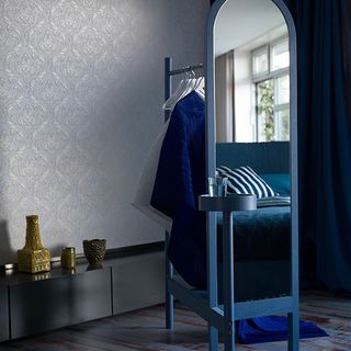 blue bedroom with sculptural clothes horse