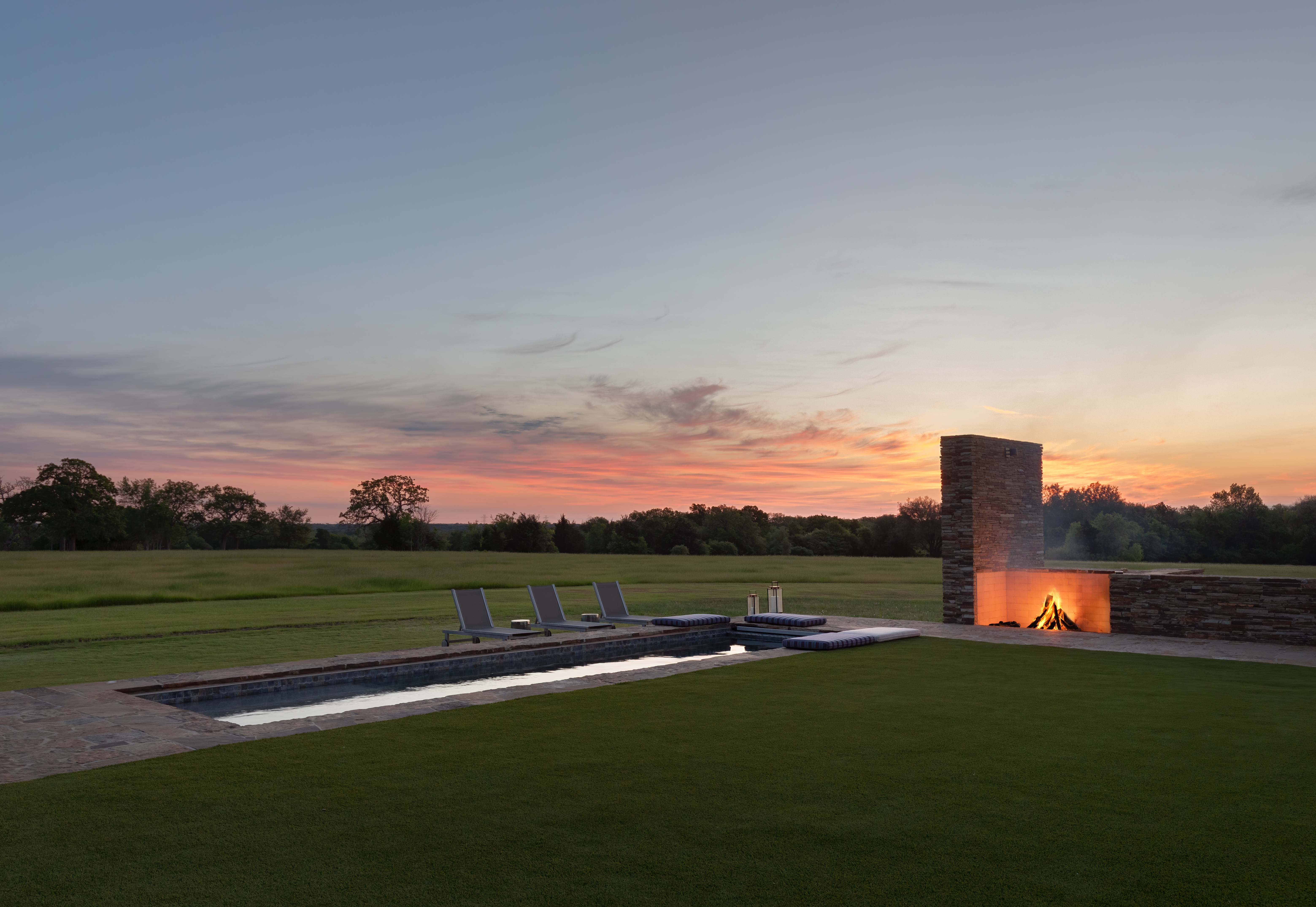 A stone firepit lit up as the sun begins to set