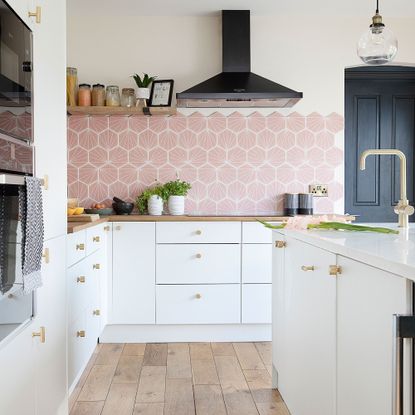 White kitchen with pink patterned tiled walls