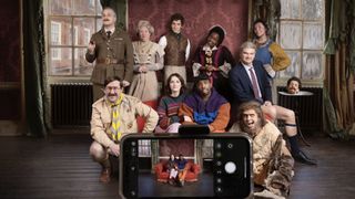 The cast of Ghosts season 4 gather together behind a mobile phone which only shows as image of the living residents - Alison (Charlotte Ritchie) and Mike (Kiell Smith-Bynoe)