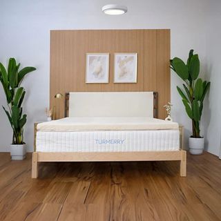 Turmerry Egg Crate Mattress Topper on a bed against wood panelling. 