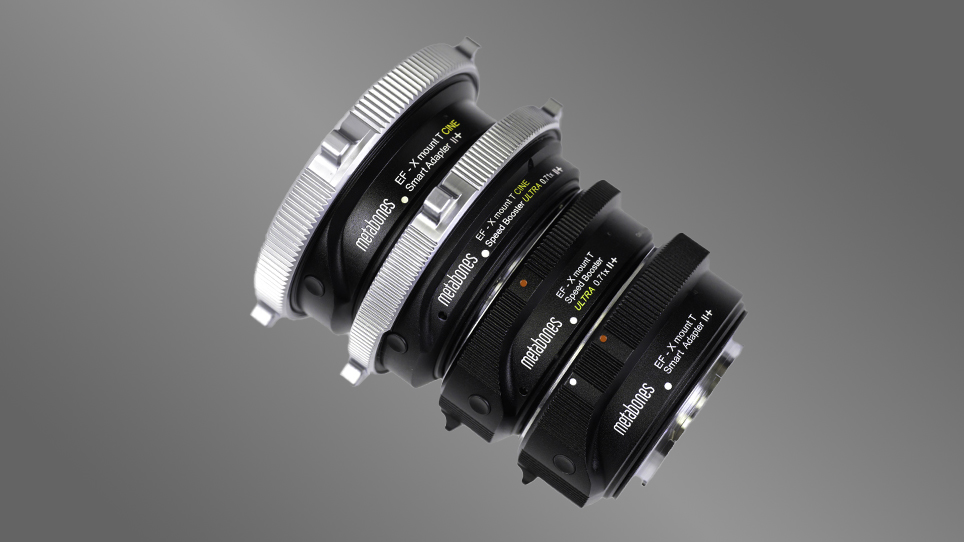 A stack of four new Canon EF to Fujifilm X adapters and speed boosters from Metabones on a gray background