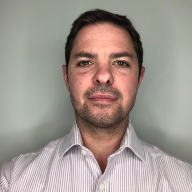 male with short dark hair wearing striped shirt