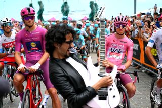 RICCIONE ITALY MAY 17 LR Jonathan Milan of Italy and Team Lidl Trek Purple Points Jersey and Tadej Pogacar of Slovenia and UAE Team Emirates Pink Leader Jersey whilst Giulio Maceroni of Italy plays guitar prior to the 107th Giro dItalia 2024 Stage 13 a 179km stage from Riccione to Cento UCIWT on May 17 2024 in Riccione Italy Photo by Tim de WaeleGetty Images