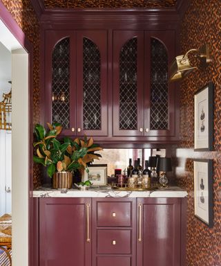 Home bar painted in moody colors and patterned wallpaper on the walls and ceilings