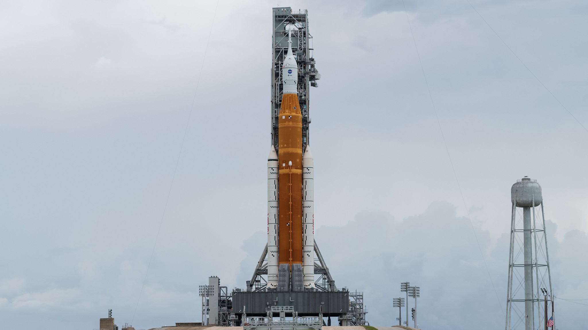 giant artemis 1 space launch system rocket on a gray cloudy background