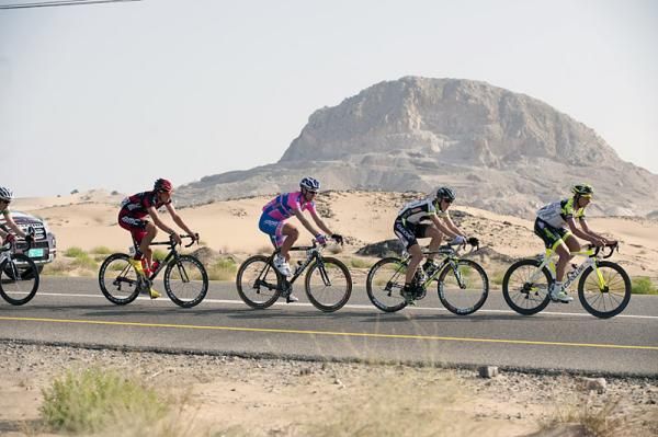 The Tour of Oman peloton in the midst of arid Omani terrain.