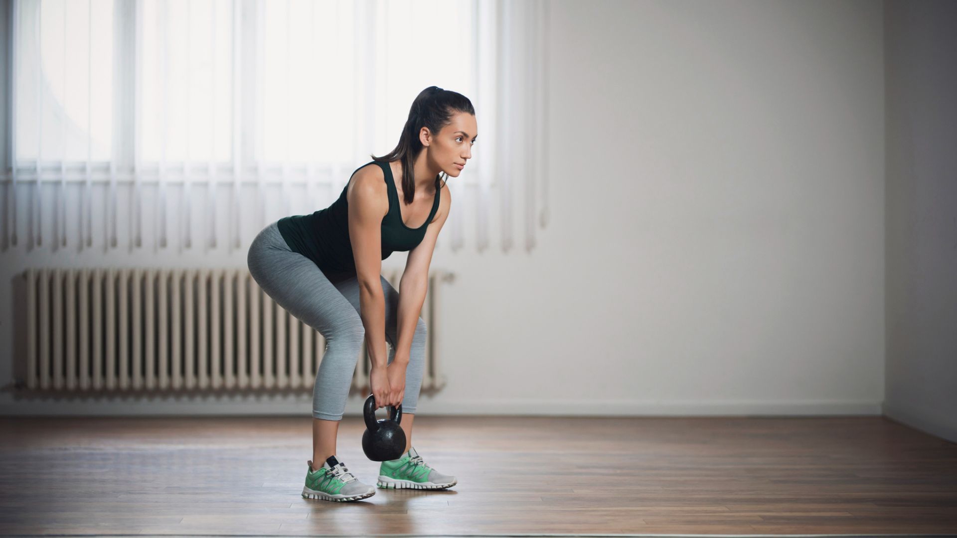 A woman performing a kettlebell deadlift