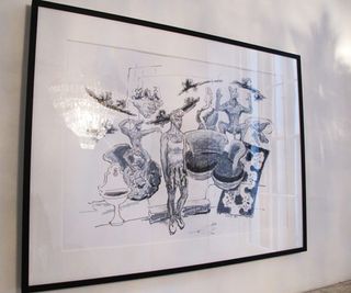 Black and white drawing in a frame with black edges hanging on a white wall